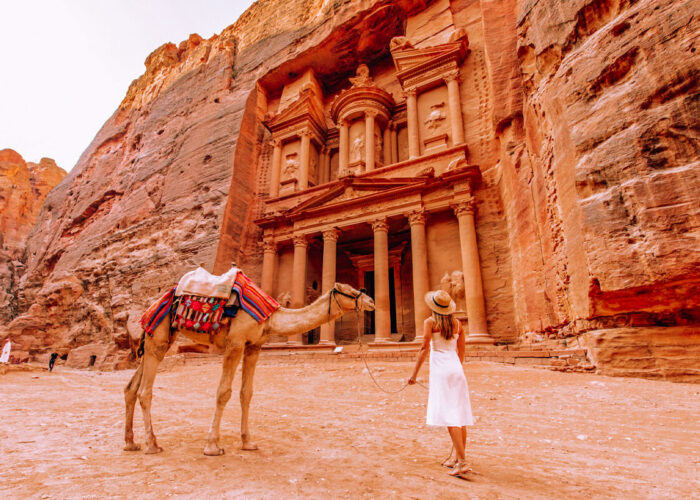 una hermosa turista sostiene un camello en petra jordania